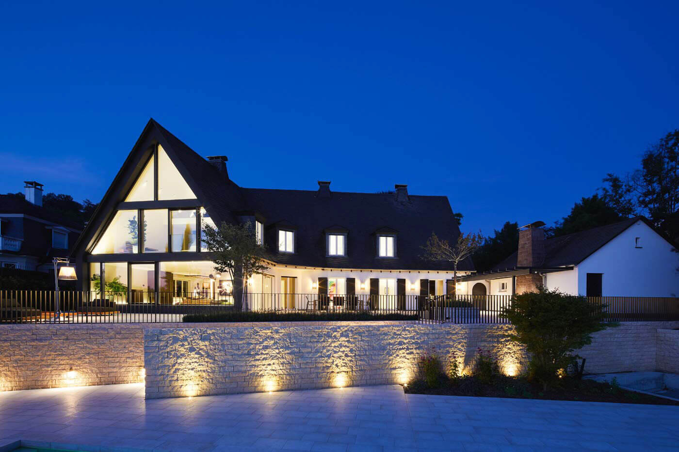 Anwesenheitssimulation im Smart Home – beleuchtetes Haus am Abend